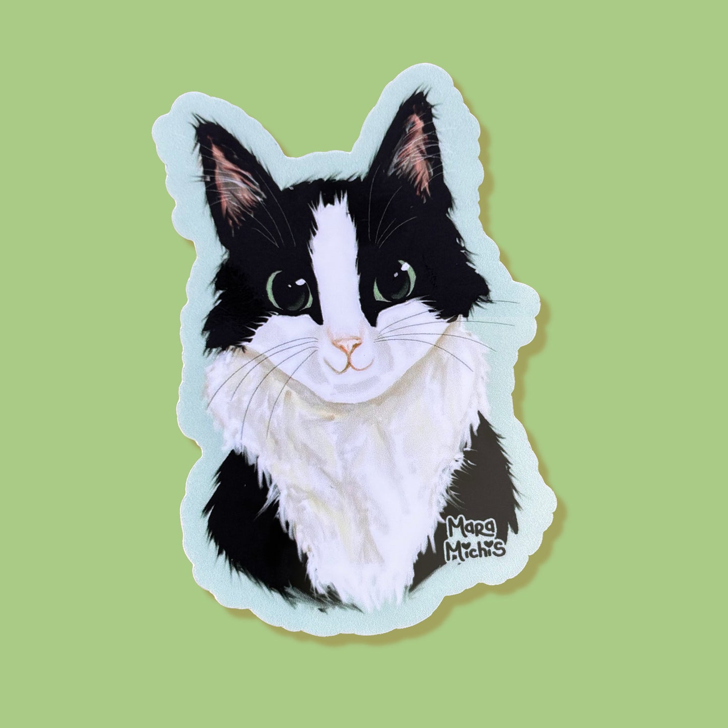 Sticker of a black and white cat on a green background